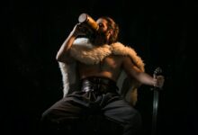 a viking in a white fur coat, drinking