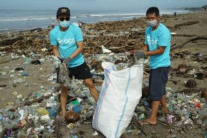 Two men picking plastics in the ocean 